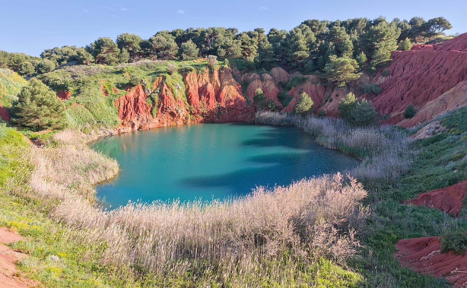 Terra rossa e lago verde nella cava di bauxite di Otranto